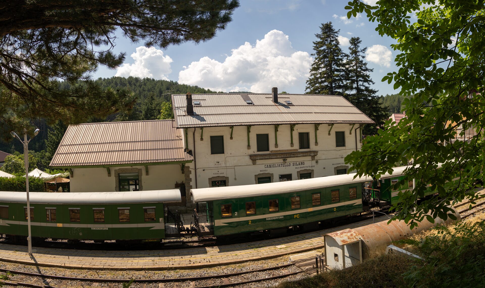 La stazione di Camigliatello Silano con le carrozze verdi del treno storico della Sila in sosta sui binari