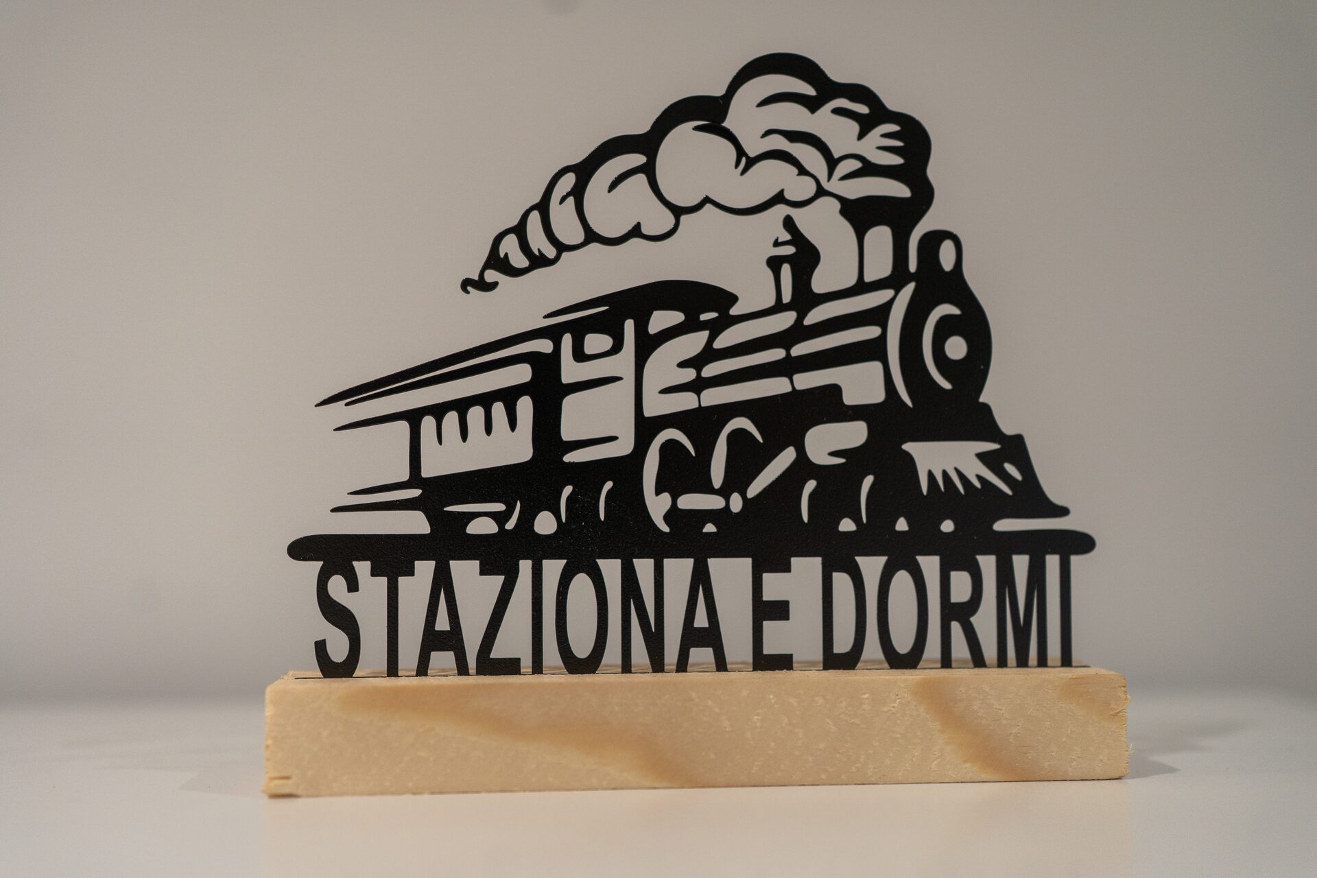 L'insegna in metallo con la locomotiva e la scritta Staziona e Dormi