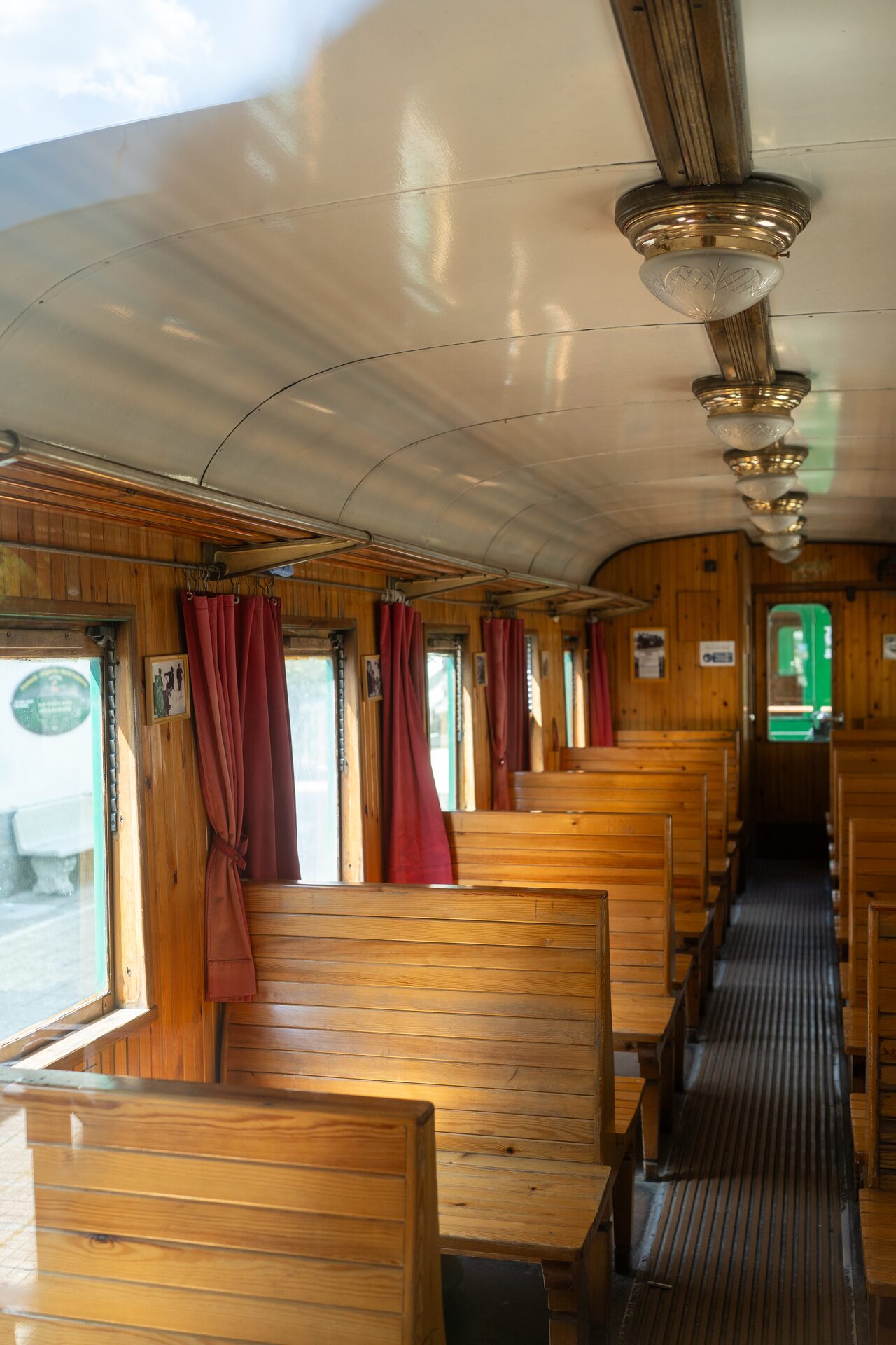 L'interno in legno di una carrozza restaurata del Treno della Sila, con panche e lampade di ottone